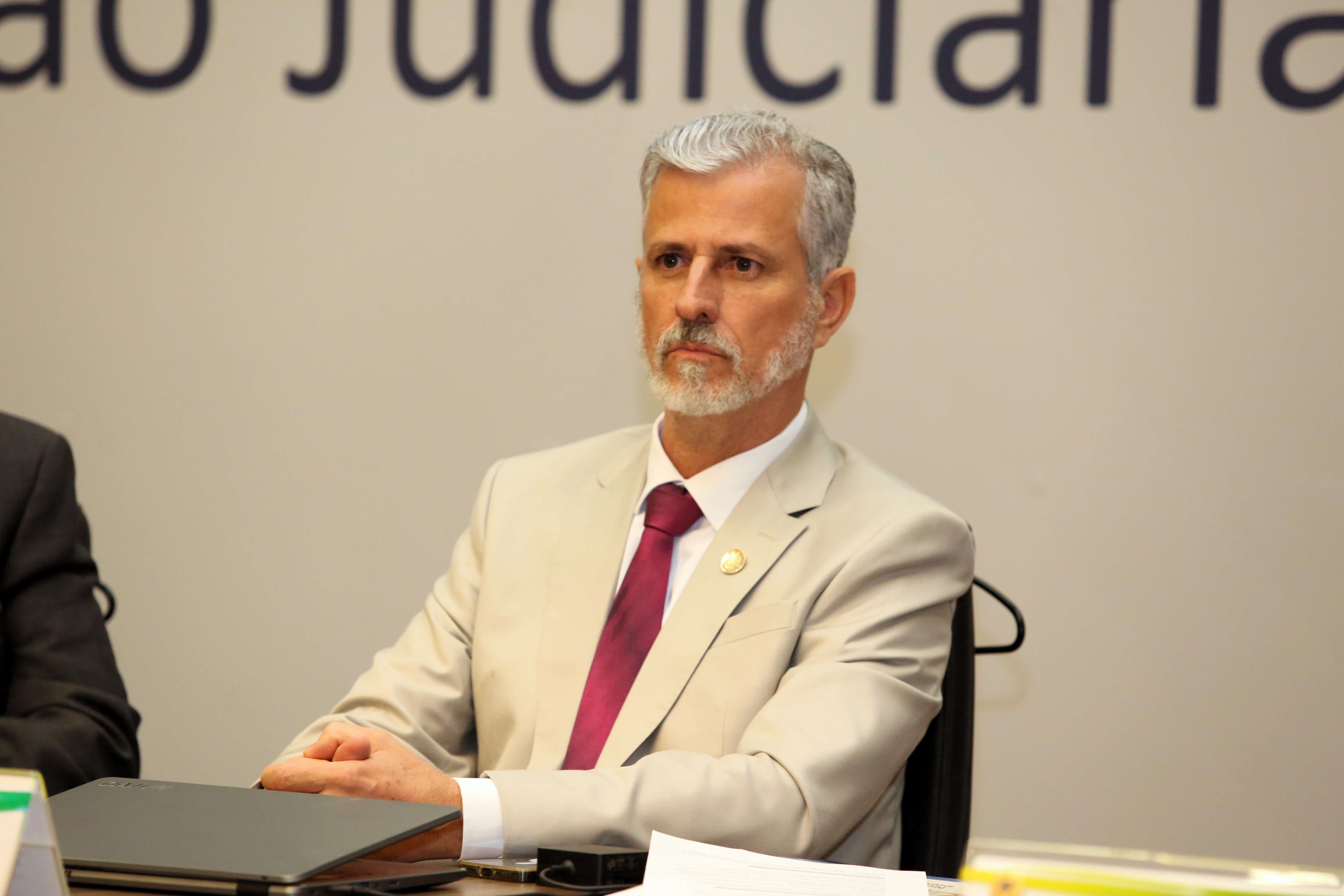 Fotografia colorida que mostra um homem branco, grisalho, usando terno e camisas claros