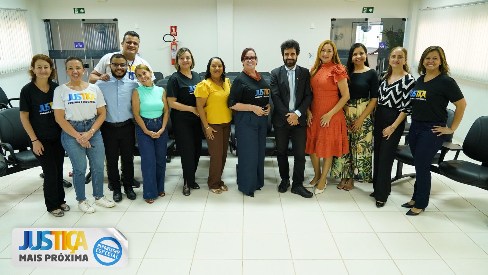 foto coloria horizontal mostra treze pessoas, homens e mulheres, no salao do juri do forum de xambioá