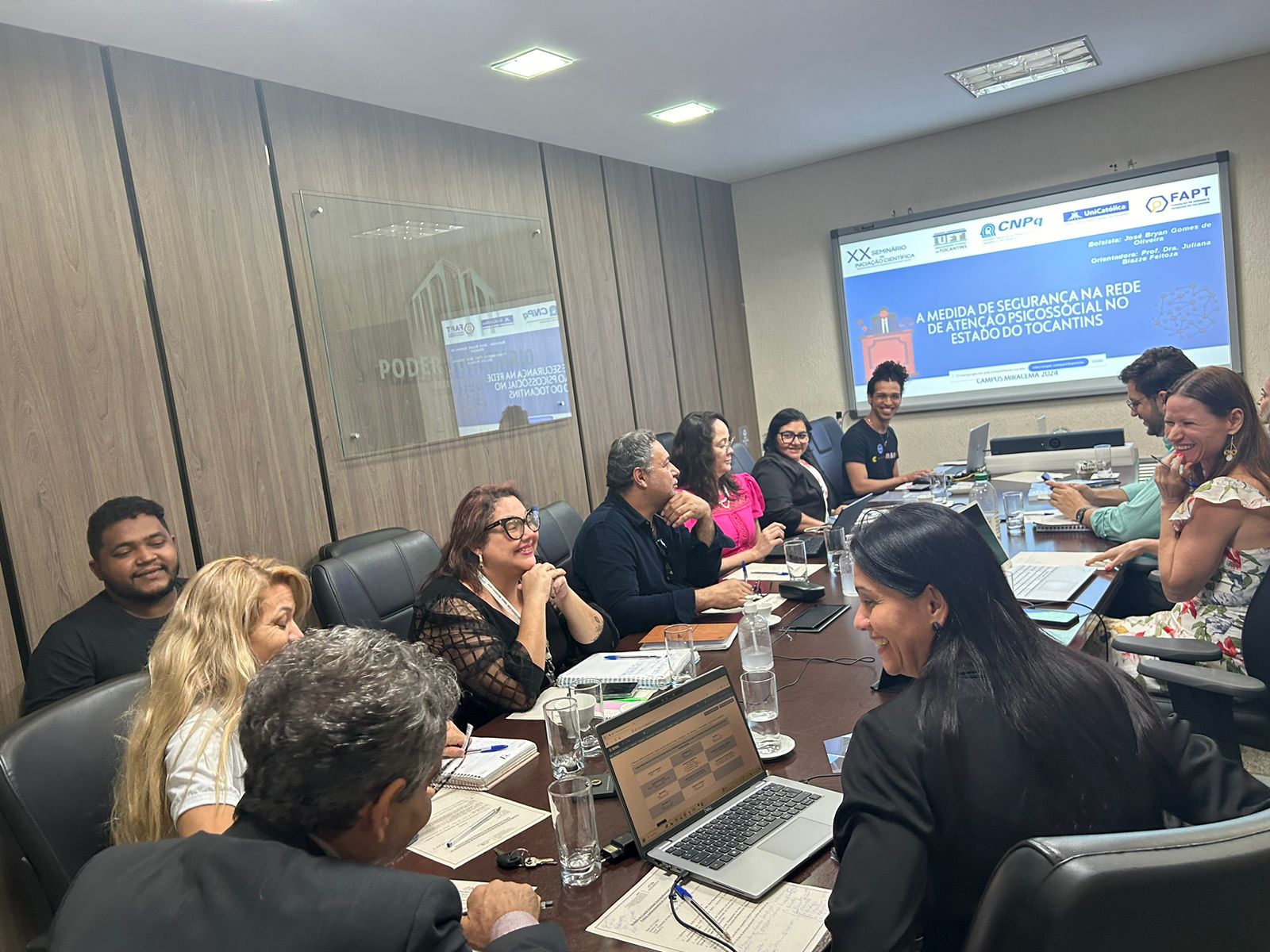 Fotografia colorida que  mostra pessoas em uma reunião