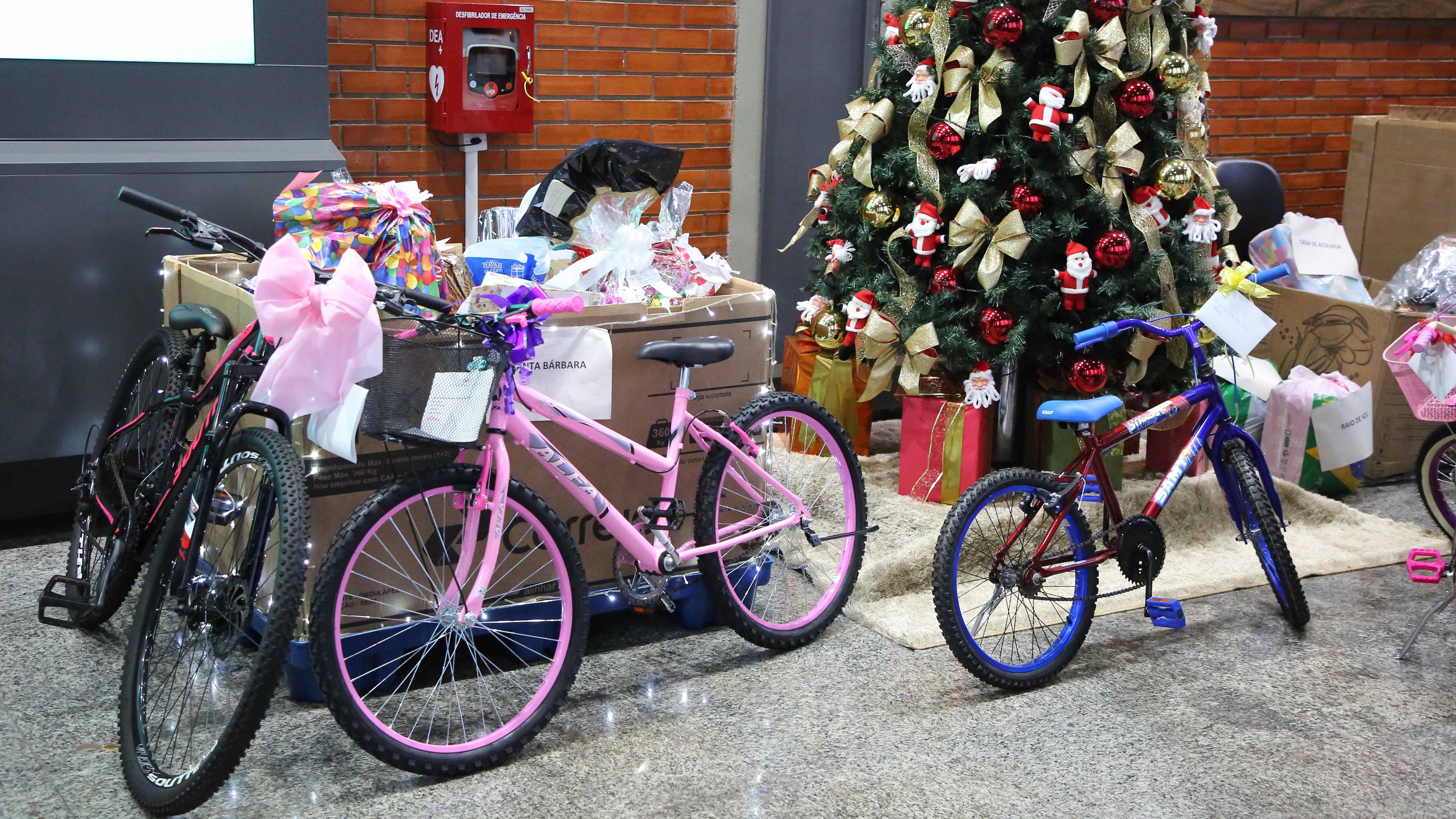 Imagem colorida que mostra brinquedos arrecadados na campanha, entre eles bicicletas.