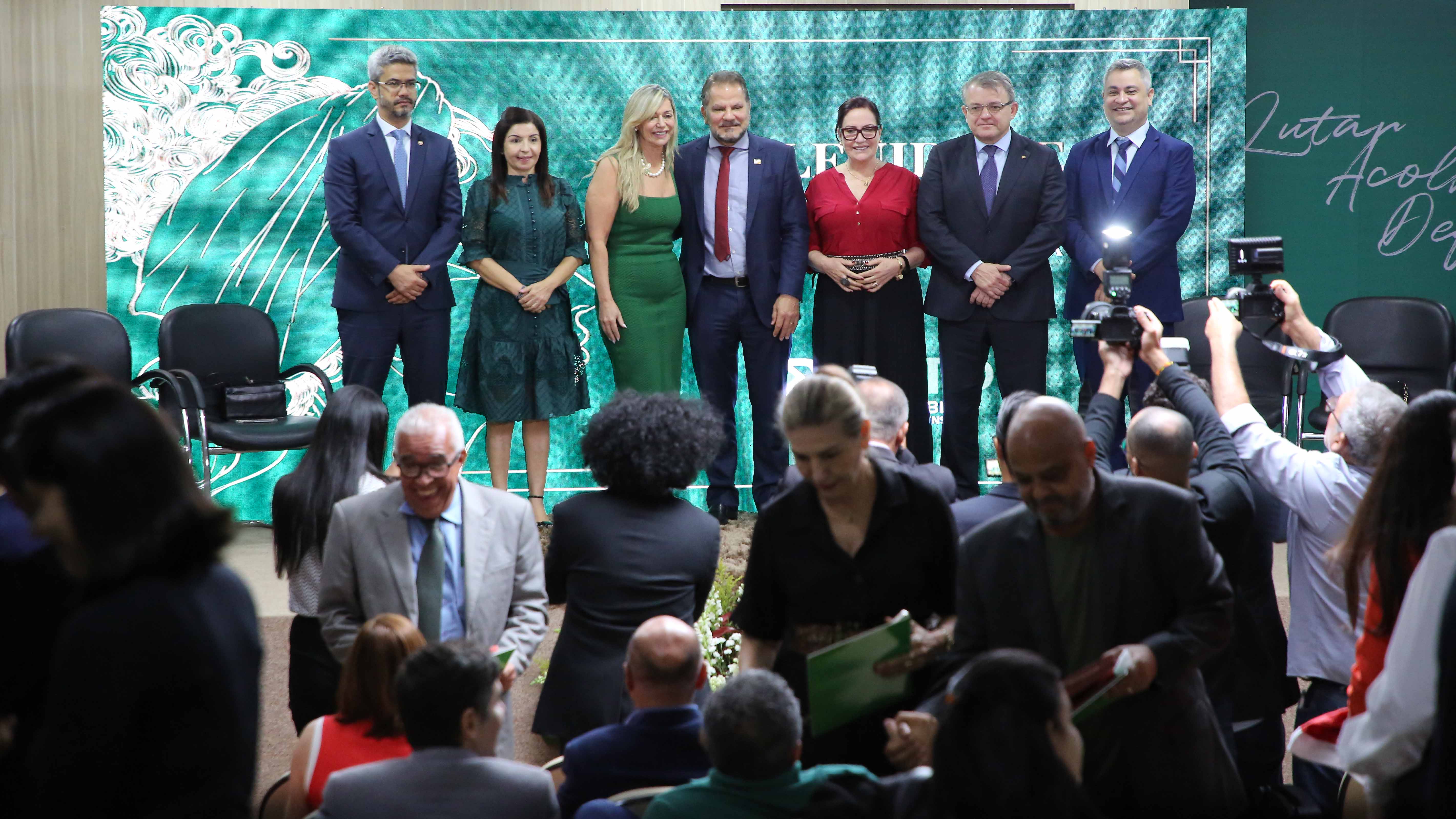Foto dos homenageados em pé, no palco do auditório