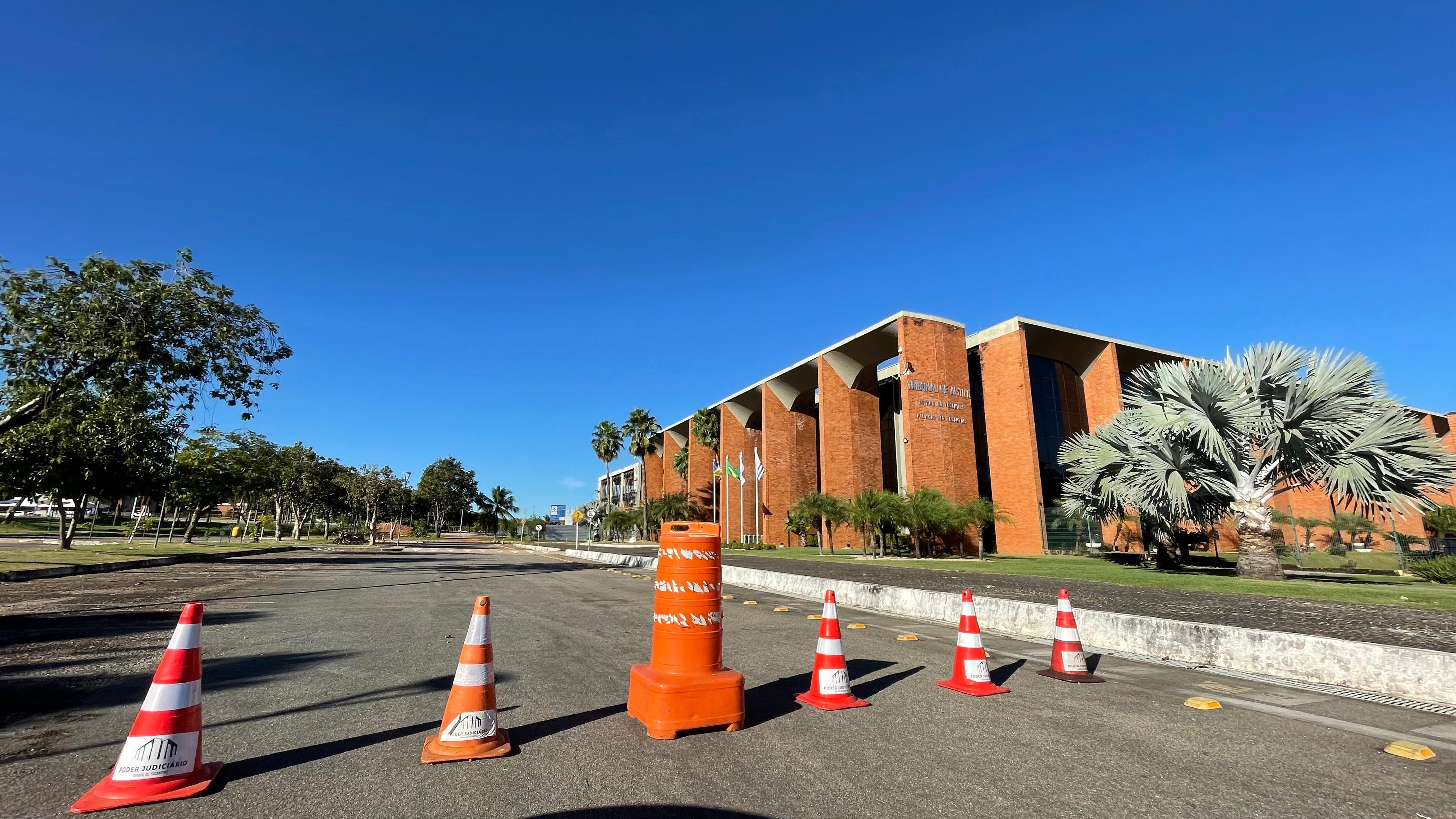 vista aerea mostra o palacio rio tocantins na praça dos girassóis cercado por estacionamento, onde cones estão cobrindo a entrada, jardim e árvores