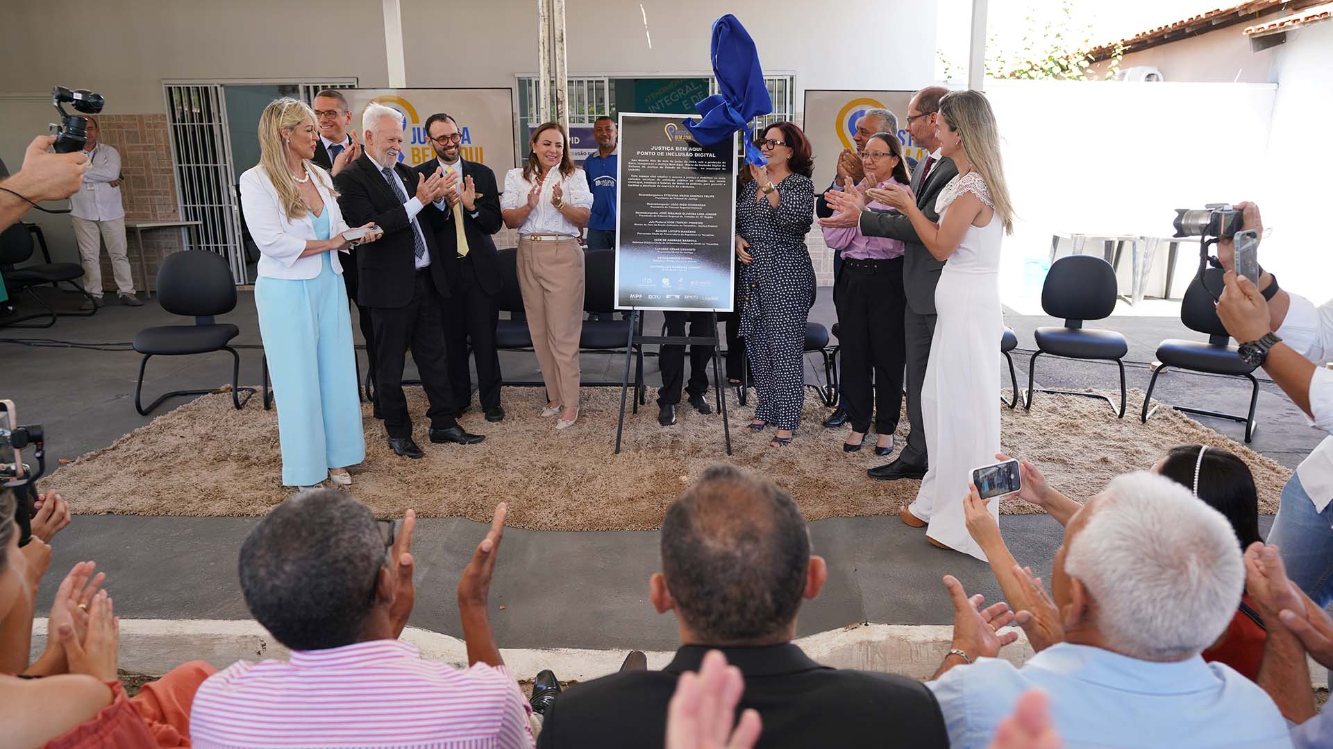 Imagem aberta com a presidente do TJTO e demais autoridades parceiras em pé ao lado da placa de instalação do Justiça Bem Aqui - Ponto de Inclusão Digital