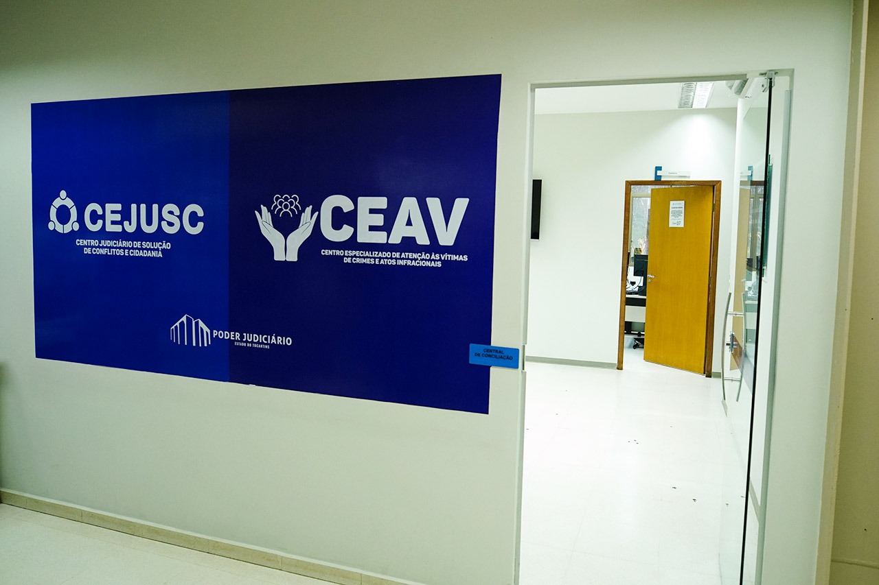 Imagem de uma placa azul com a identificação Cejusc e Ceav; do lado direito uma porta aberta