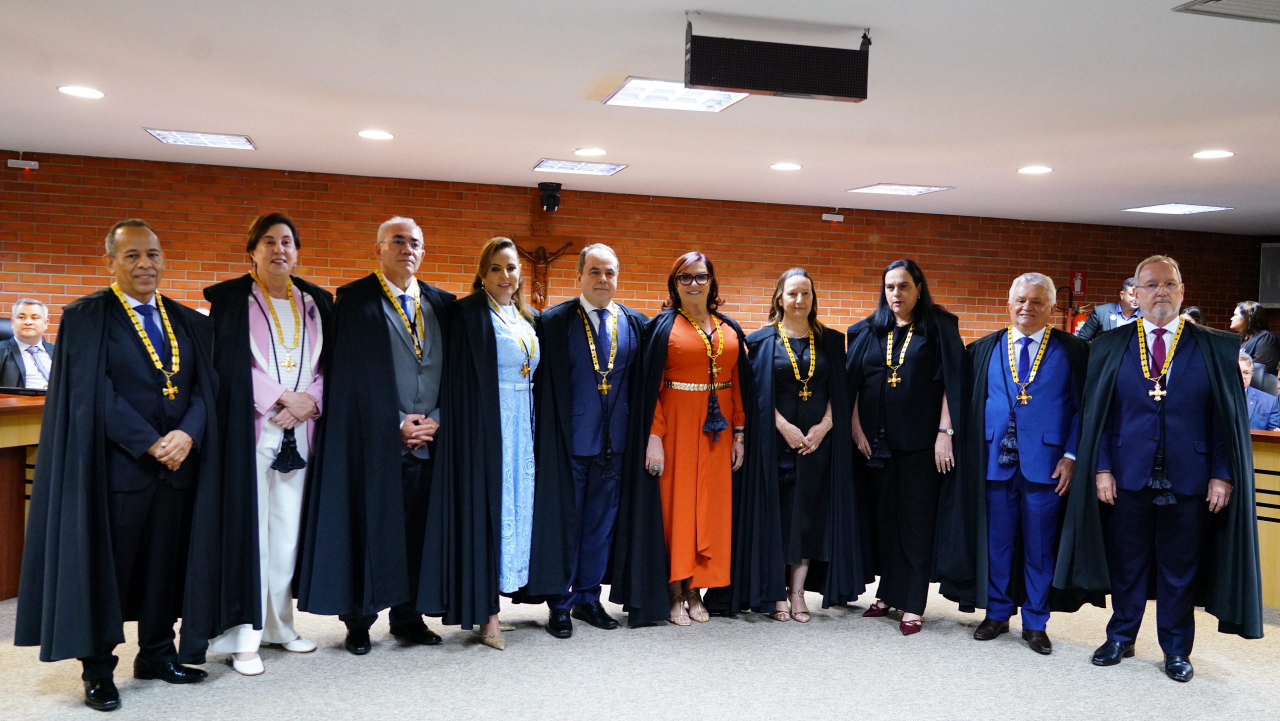 Homens e mulheres de togas com medalhas condecorativas posando no auditório do Judiciário tocantinense