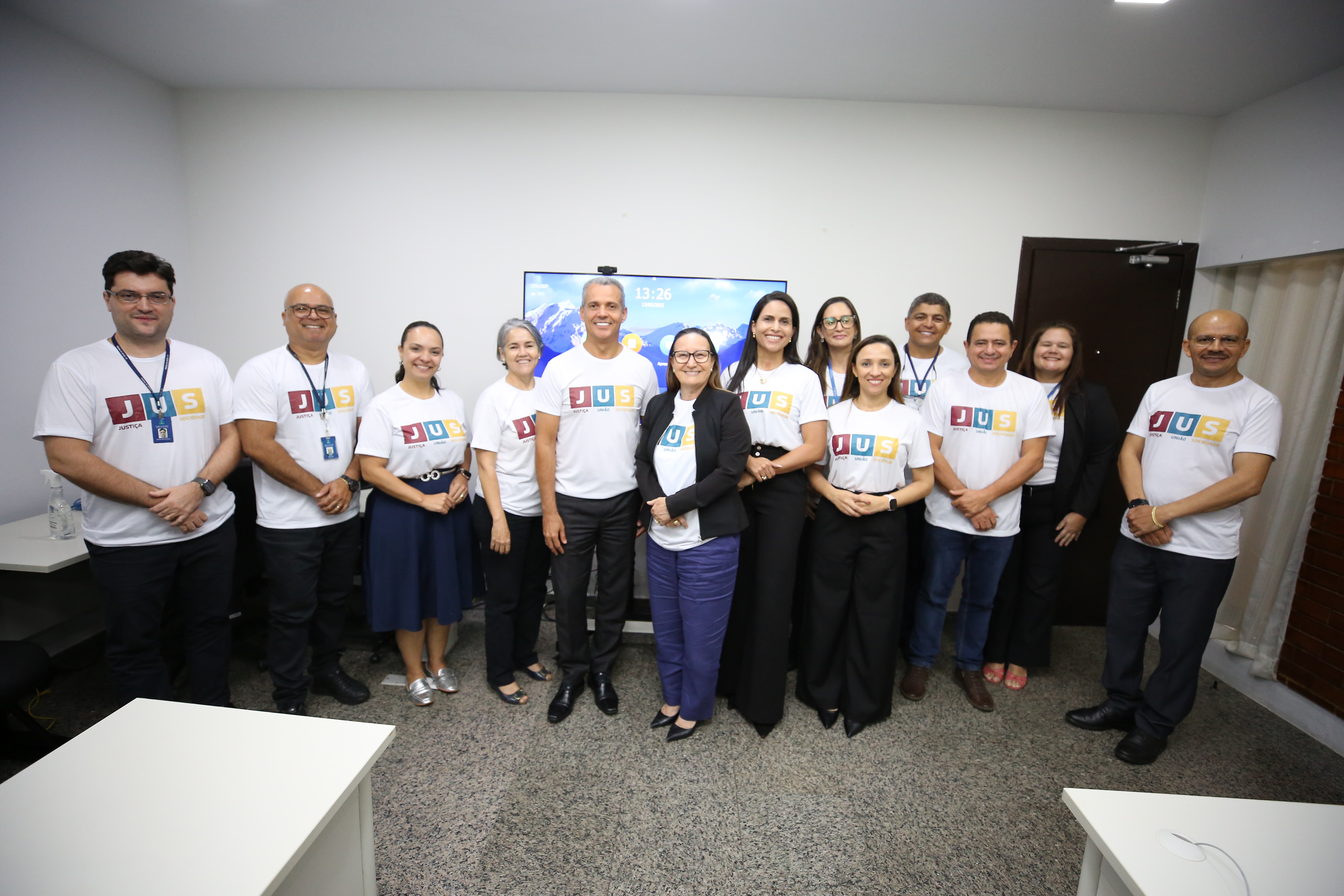 Imagem mostra a desembargadora Maysa ao centro ao lado do grupo de diretores reunido. Todos estão sorrindo, com camisetas da gestão e posicionados em linha.