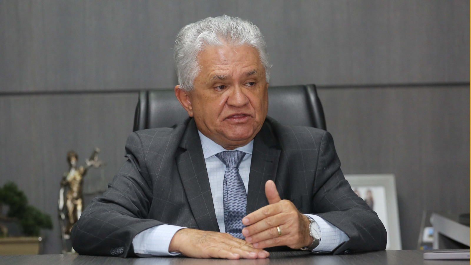 Boneco do desembargador Lamounier, um senhor de cabelos brancos e pele clara; ele usa terno e gravata cinza e camisa branca