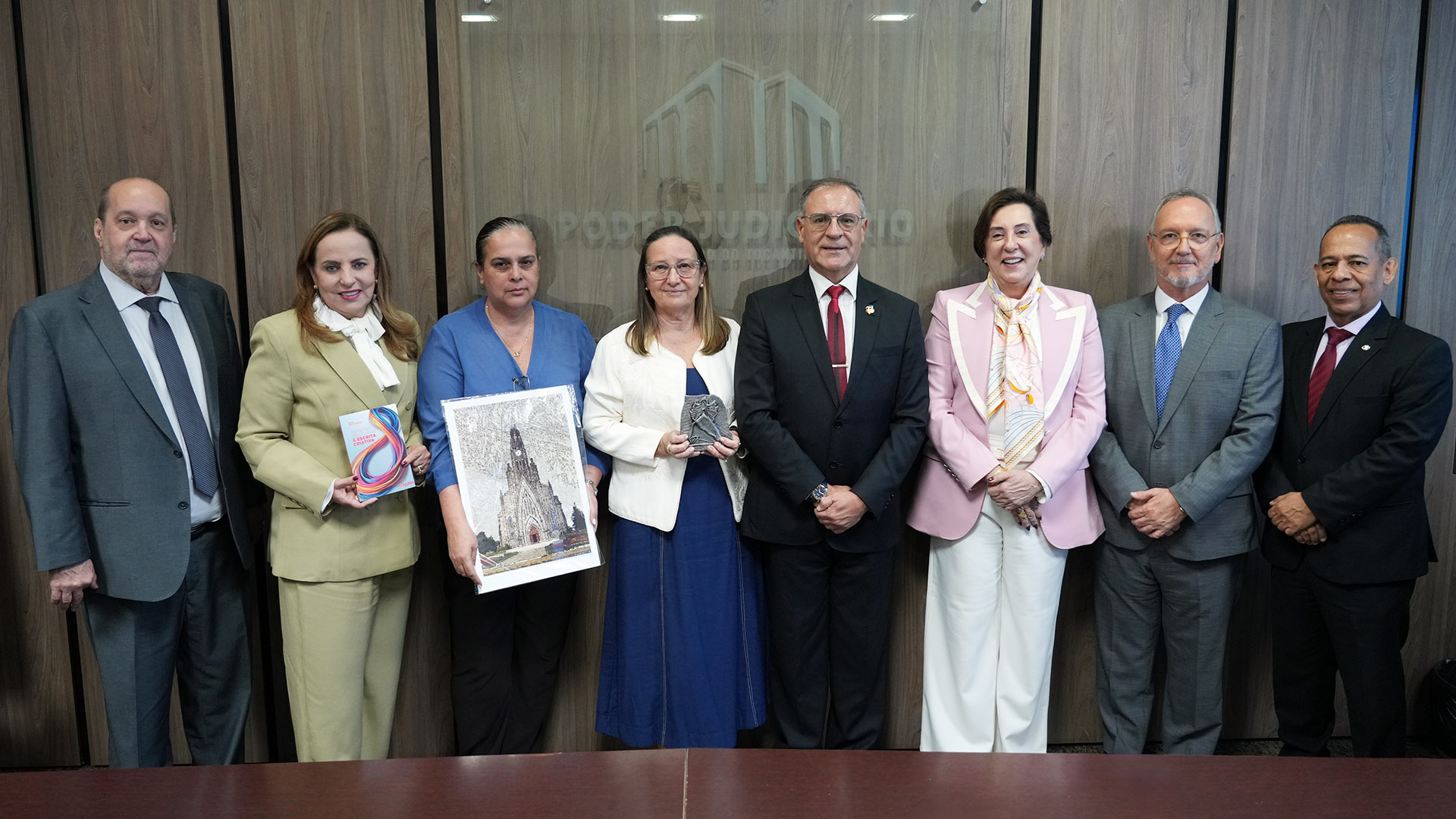 Oito desembargadores, sendo quatro homens e quatro mulheres, em pé posando para a foto 
