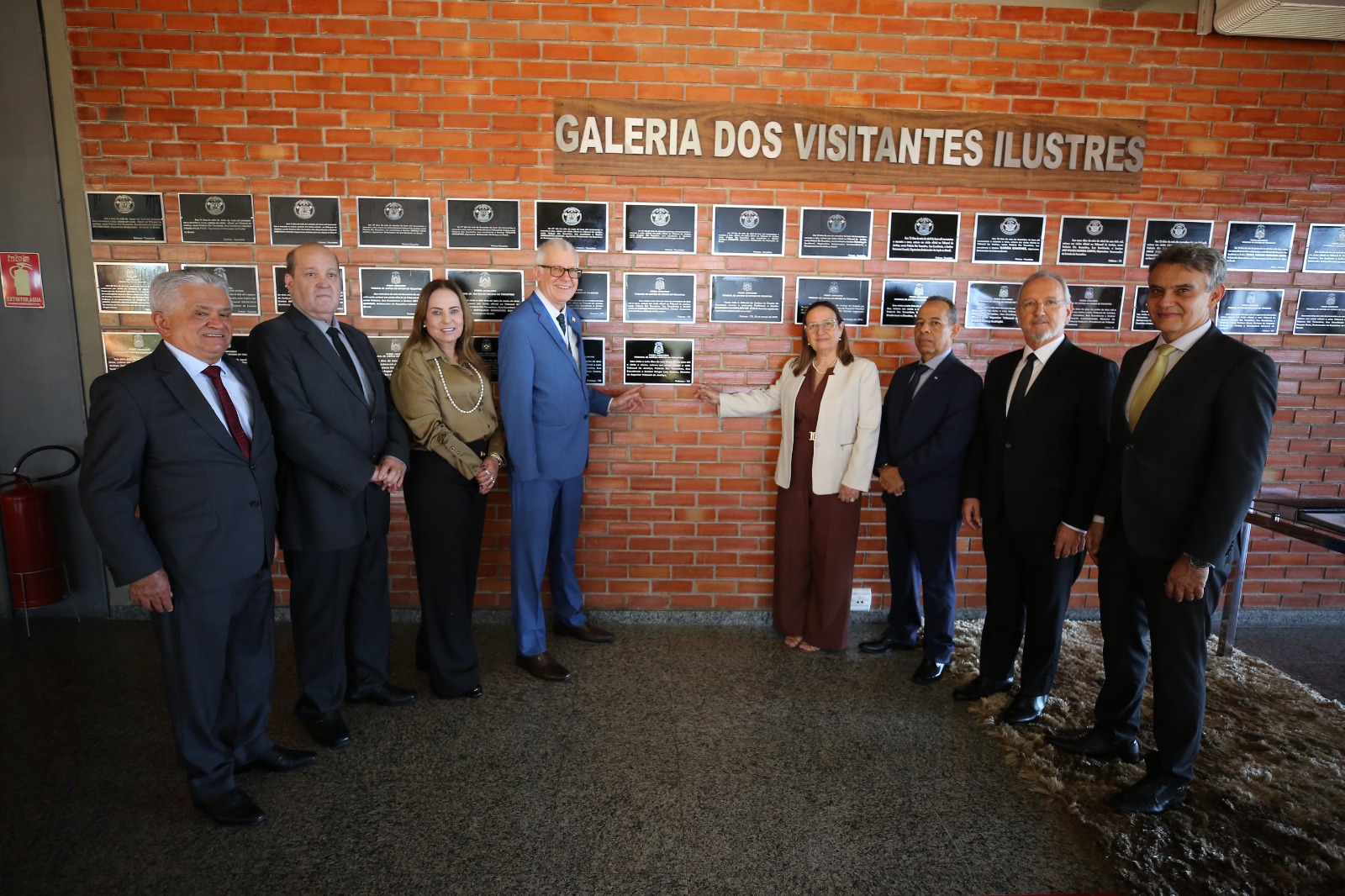Autoridades em pé, reunidas em frente à galeria de visitantes ilustres