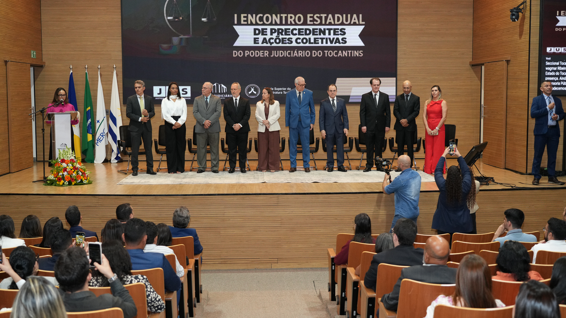 Várias autoridades em pé no centro do palco; ao centro o ministro do STF recebe medalha