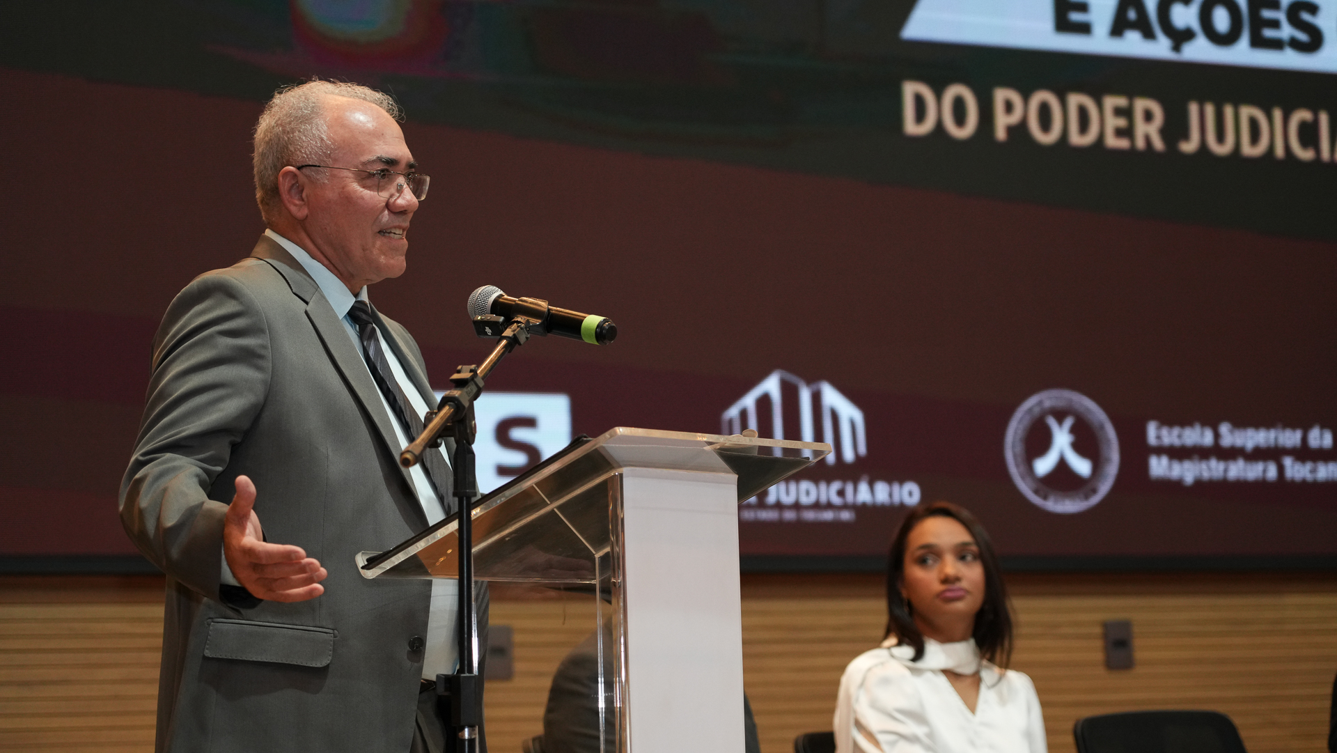 Desembargador Adolfo Amaro, homem de cabelos brancos, de óculo, usa terno e gravata em tons de cinza e camiza clara