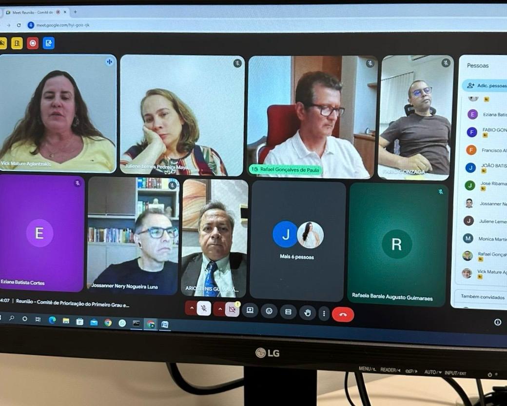 Foto de tela de computador exibindo homens e mulheres em reunião virtual