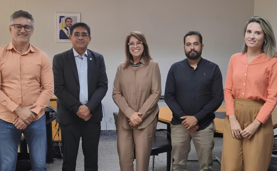 Homens e mulheres em pé posando para foto durante visita institucional