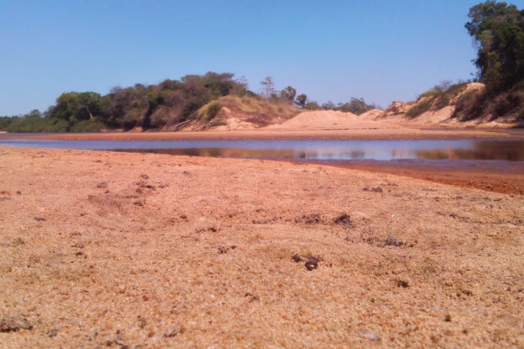 Imagem de terra vermelha e um pouco de água que sobrou de um rio