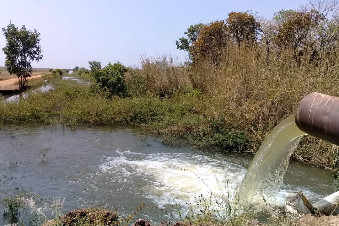 Imagem de um grande cano jorrando água em abundância em um reservatório