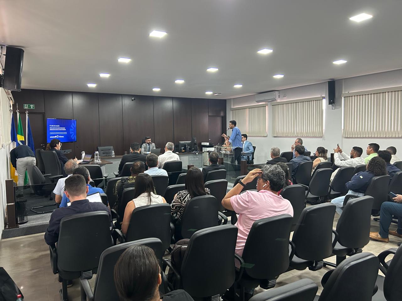 Imagem aberta de audiência pública com várias pessoas participando em um auditório