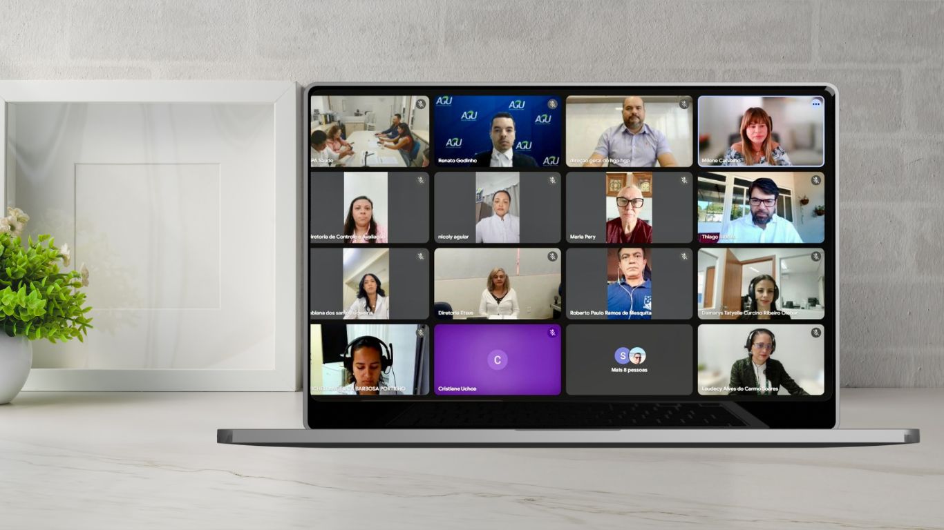 Imagen de um monitor projetando na tela as janelas com a imagem dos participantes de uma reunião virtual