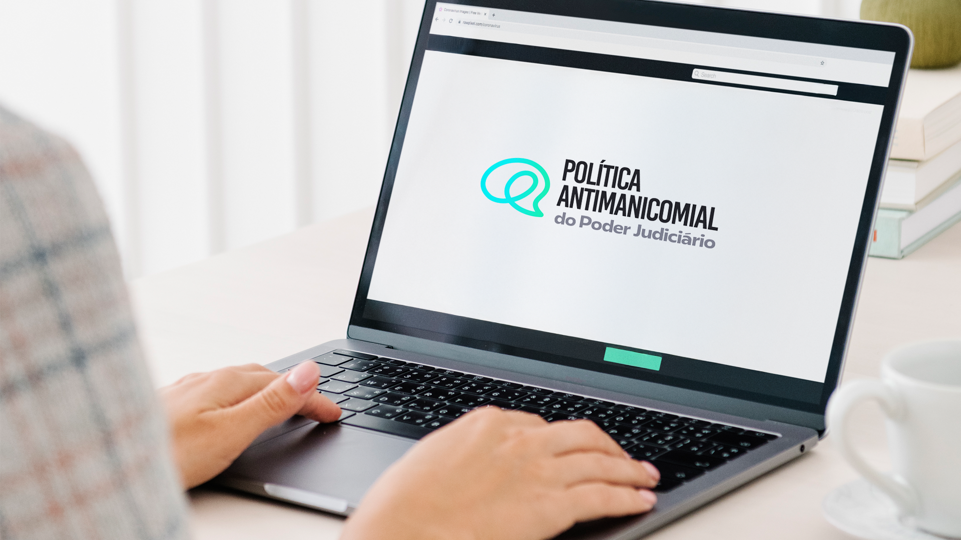  Imagem de mãos manuseando teclado de notebook que apresenta mensagem sobre política antimanicomial do Judiciário