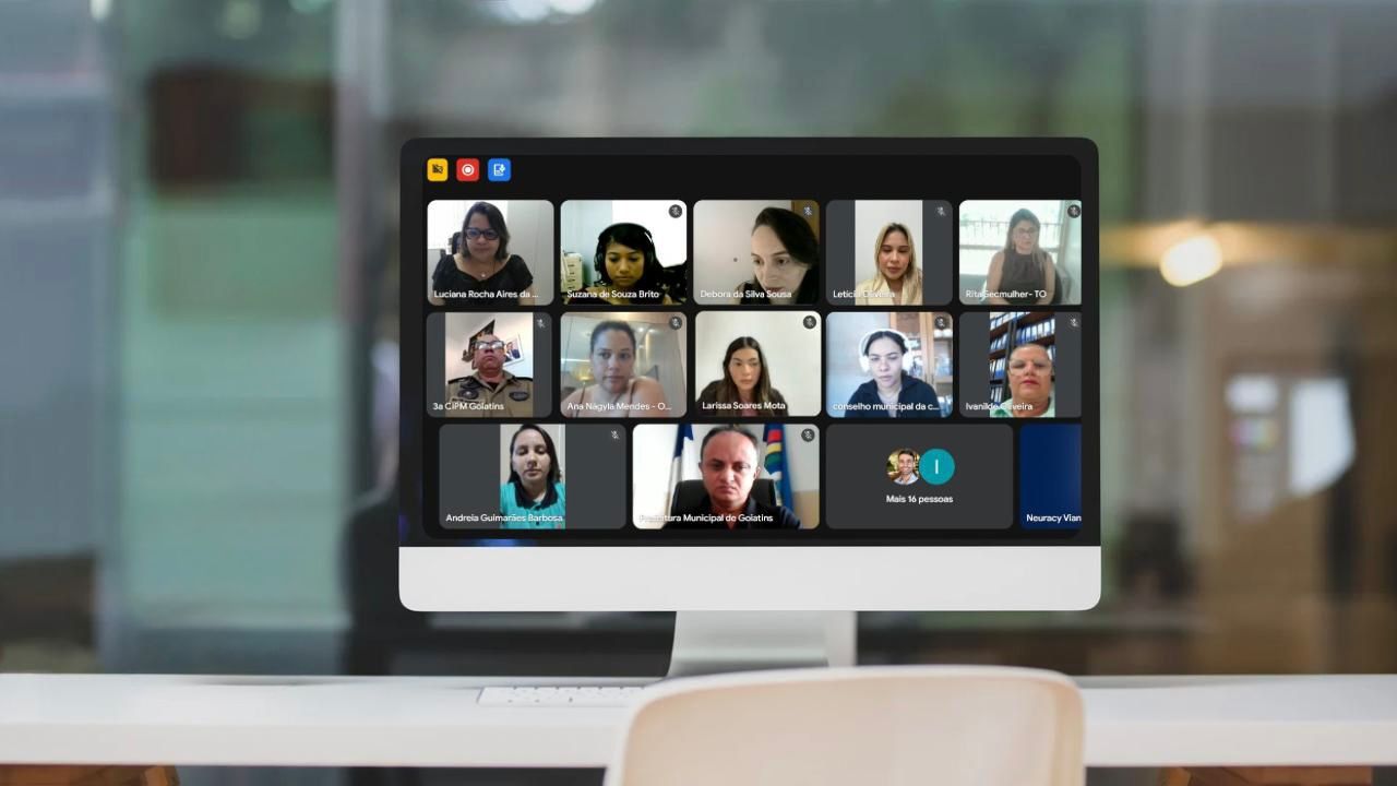 Imagem mostra um computador de mesa com uma tela exibindo várias pequenas janelas com pessoas que participam de uma reunião online.