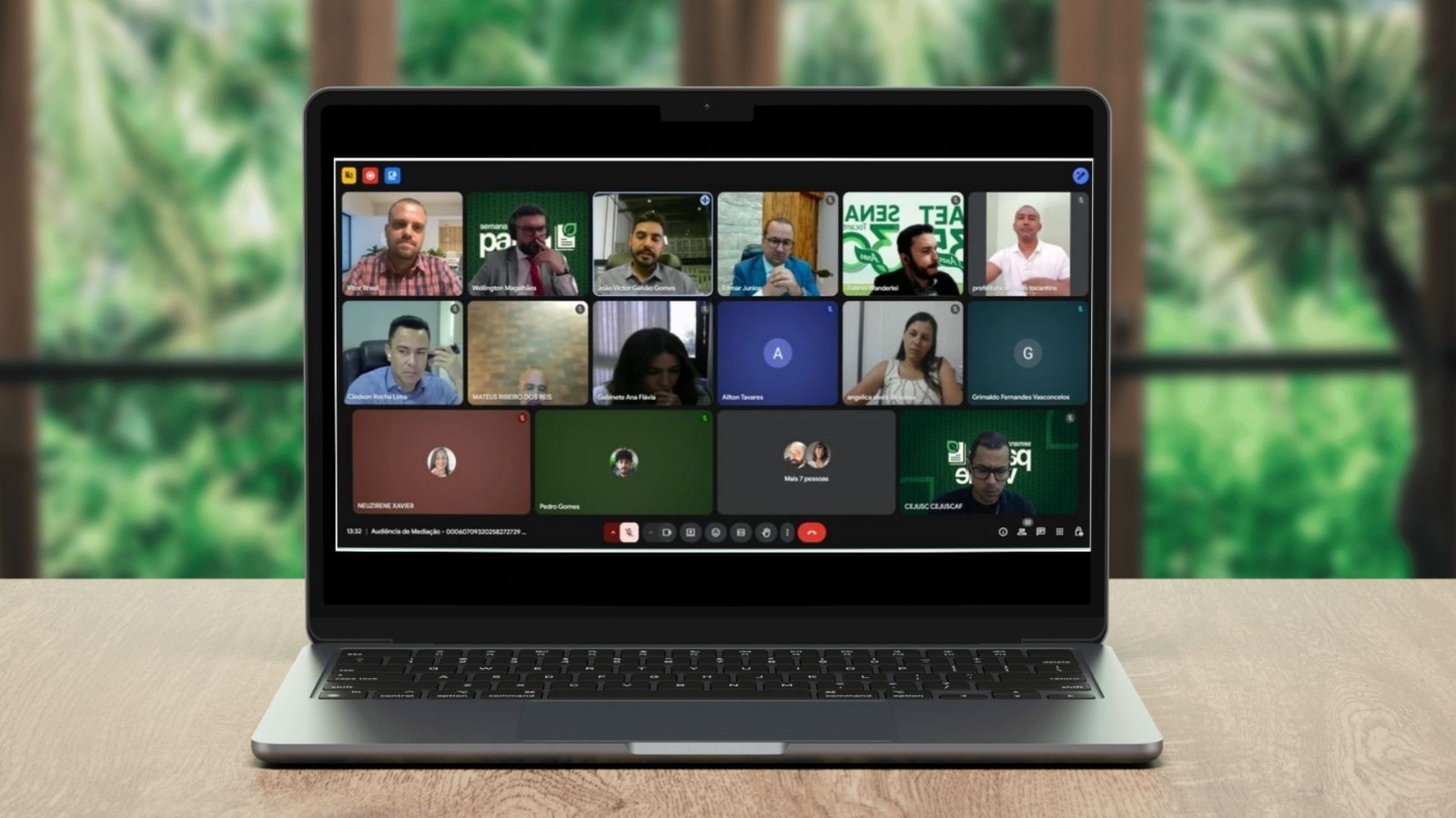 Imagem de uma tela de computador portátil com um layout de grade de várias janelas de vídeo. Cada janela exibe uma pessoa participando da audiência online.