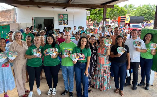 Um grupo de pessoas em pé segurando um material institucional 
