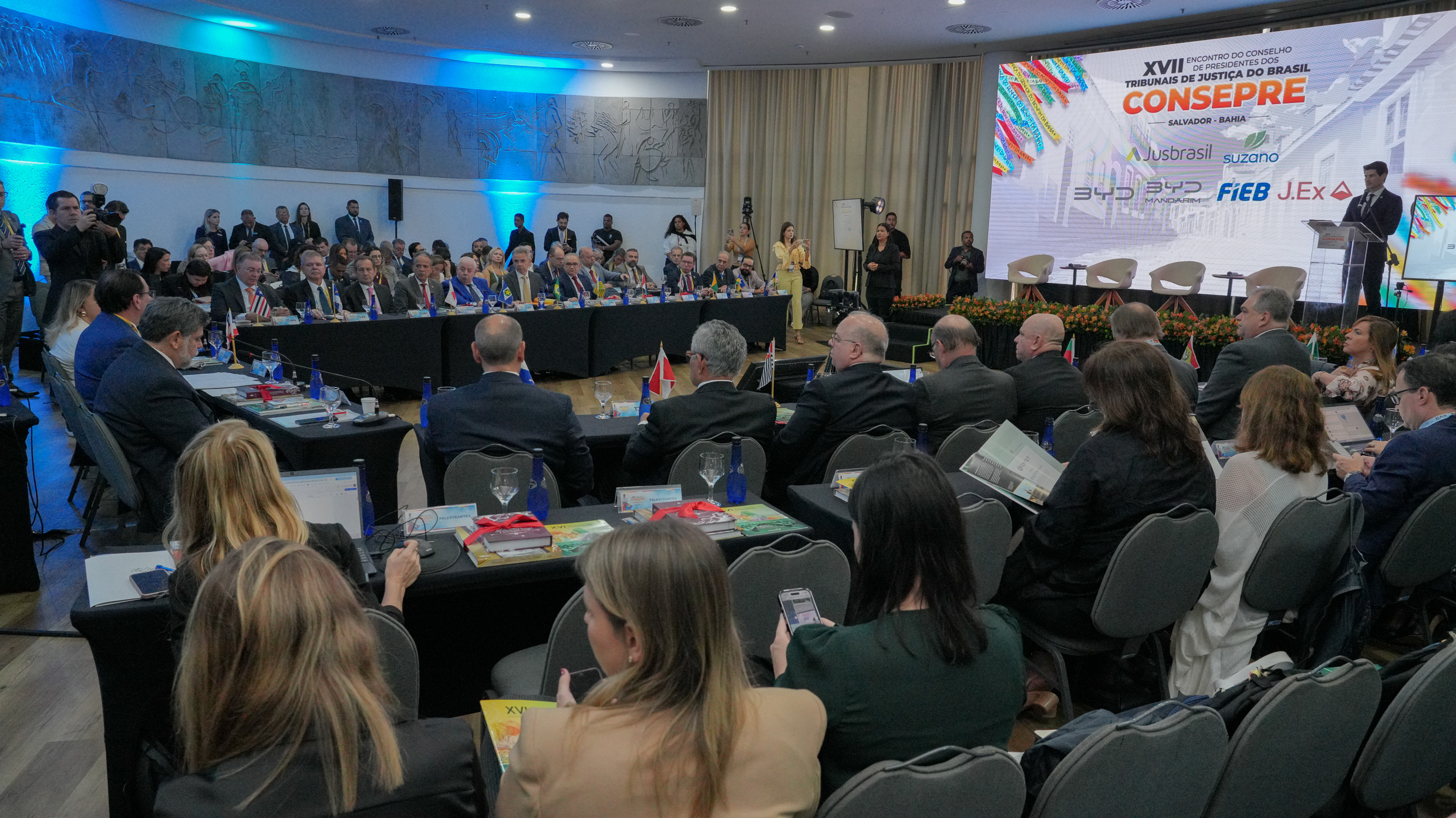 A imagem mostra a cerimônia formal do XVII Encontro do Conselho de Presidentes de Tribunais de Justiça do Brasil (Consepre), realizada em um amplo salão decorado, com plateia e autoridades no palco, todos em trajes formais.