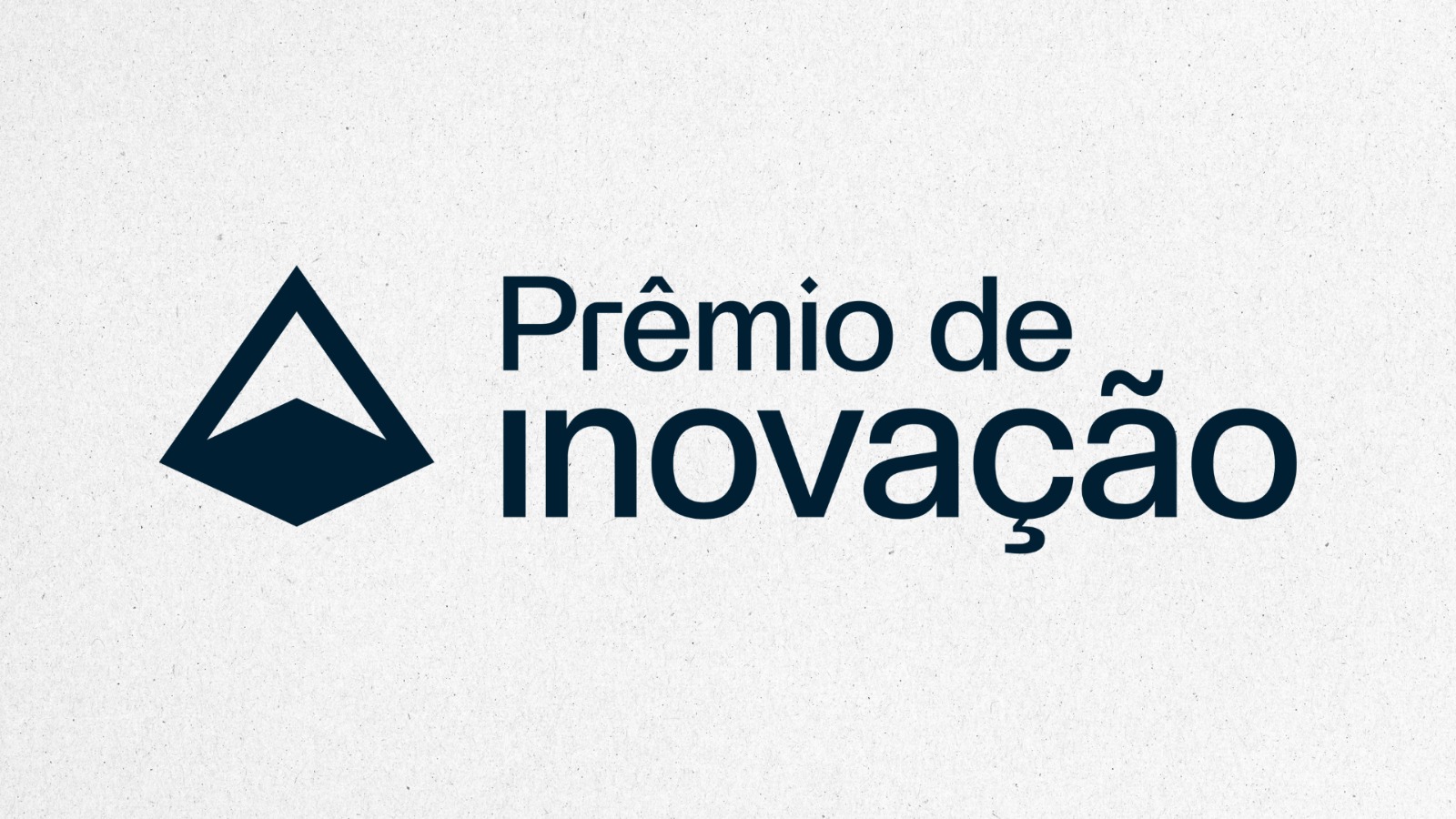 Imagem de mulher branca de cabelos lisos, castanhos, soltos, na altura dos ombros. Ela veste blusa preta com blazer rosa e está sentada em estação de trabalho. Atrás, uma imagem representando setor de Tecnologia