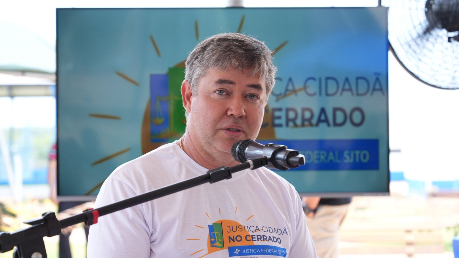 A imagem mostra o juiz William Trigilio da Silva, da Comarca de Ponte Alta do Tocantins, falando ao microfone durante a ação Justiça Cidadã no Cerrado.