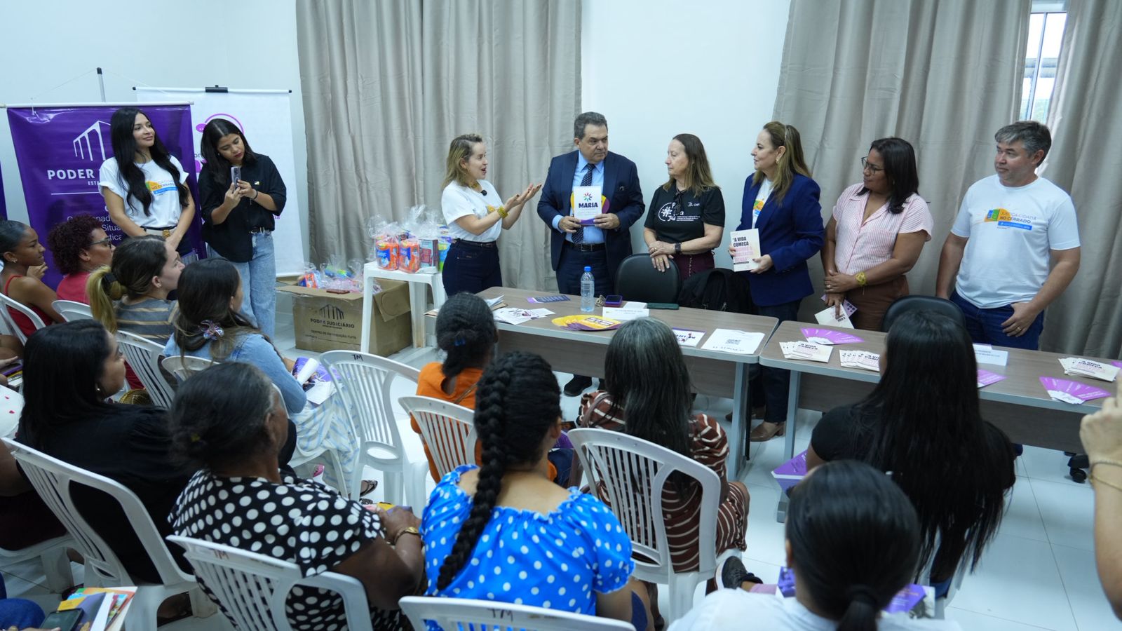 A imagem mostra uma roda de conversa focada no combate à violência contra a mulher, durante a ação do Pop Rua Jud, com várias pessoas, incluindo um grupo de pessoas sentadas ouvindo uma apresentação.