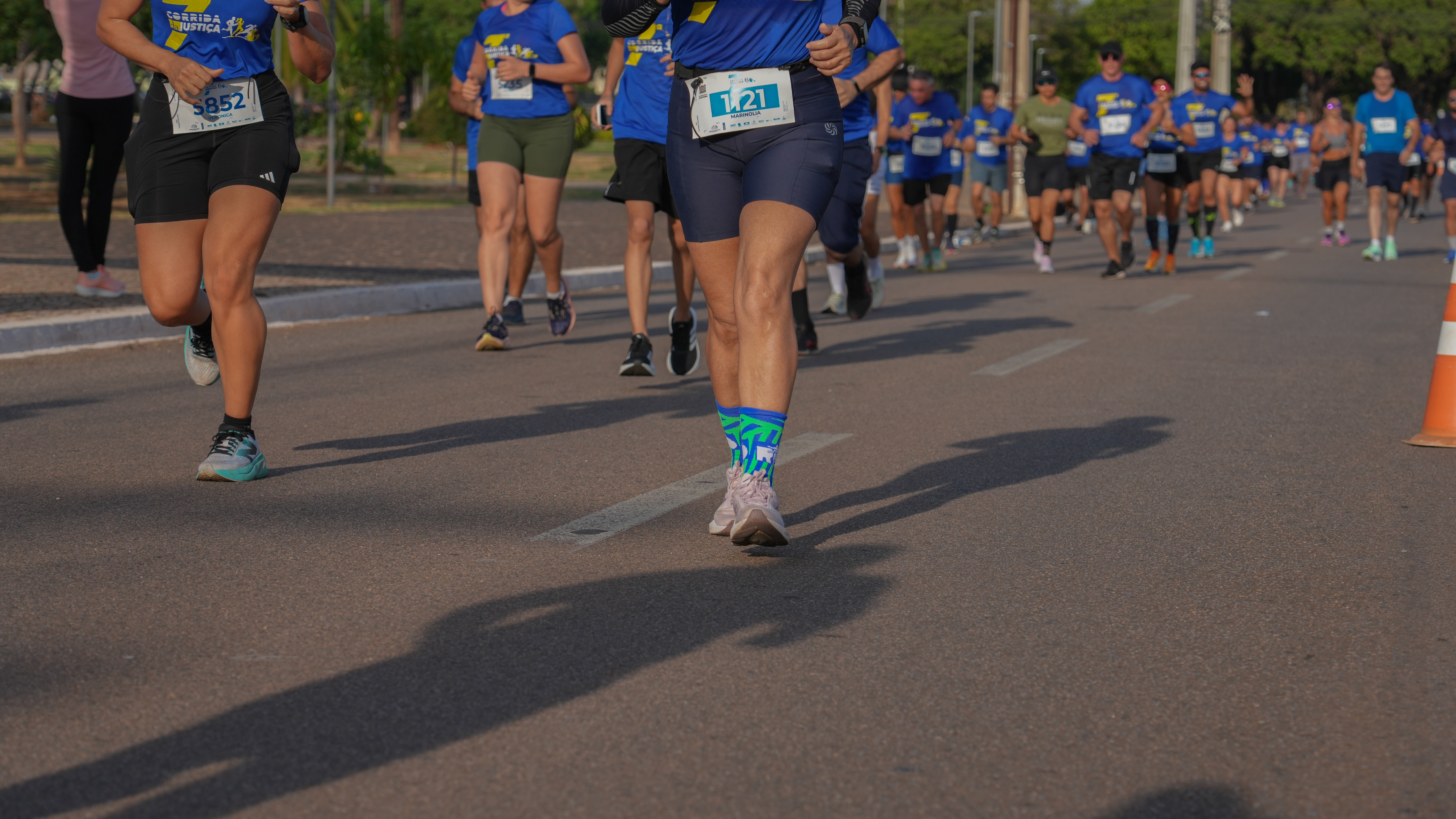 Imagem aberta com vários corredores e duas mulheres com shortes pretos e tênis em primeiro plano