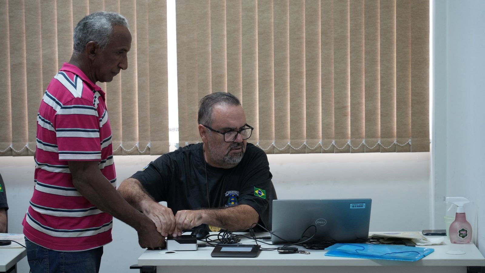 A imagem mostra um homem colhendo a digital do dedo polegar durante o projeto JUS em Ação, realizado em Novo Acordo.