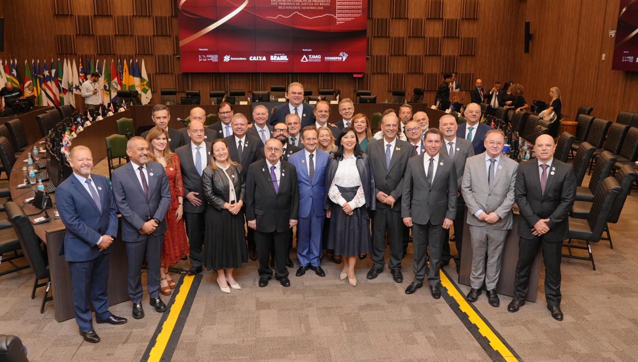 Presidentes  dos Tribunais de Justiça do Brasil posam para foto oficial no plenário, reunidos à frente da mesa de reuniões, com o painel do XVIII CONSEPRE ao fundo. Todos estão alinhados e vestidos formalmente.