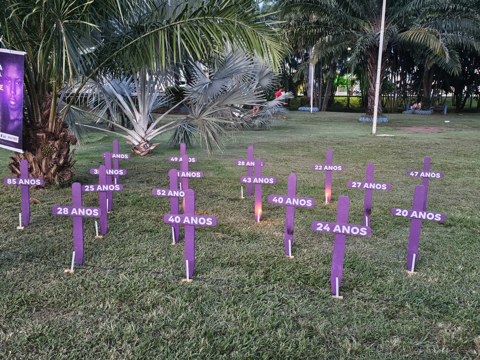 Cruzes roxas fincadas na grama do Parque Mutuca formam um memorial simbólico em homenagem às vítimas de feminicídio em Gurupi. Cada cruz traz a idade das mulheres assassinadas e está acompanhada por velas acesas, representando as 17 vítimas registradas nos últimos três anos e reforçando o momento de memória e reflexão promovido pelo movimento “Vozes que não se calam”.