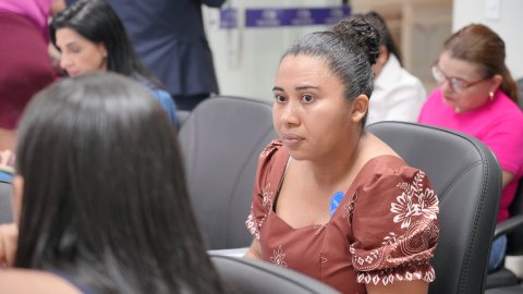 Leonilda Barreira da Silva Almeida acompanha audiência com expressão atenta, representando as filhas Cecília, de 9 anos, e Celina, de 2, durante atendimento no mutirão de saúde.