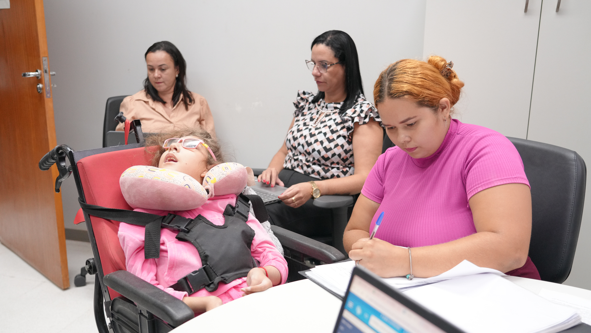 Jéssica acompanhada da filha durante audiência que busca garantir atendimento e dignidade.