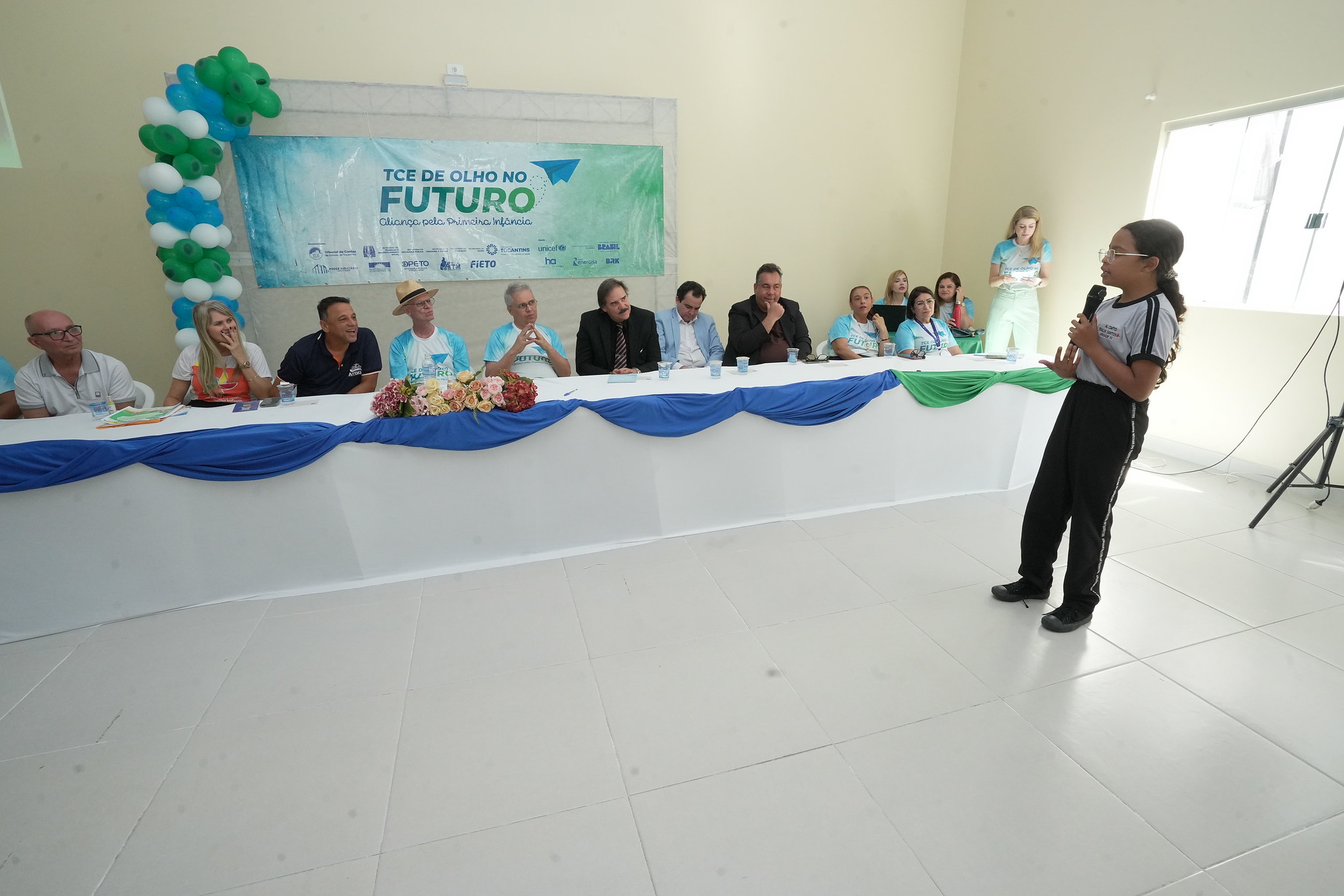Estudante faz uso da palavra durante encontro do programa “TCE de Olho no Futuro – Aliança pela Primeira Infância”, diante de autoridades e representantes de instituições públicas reunidos em mesa de debate