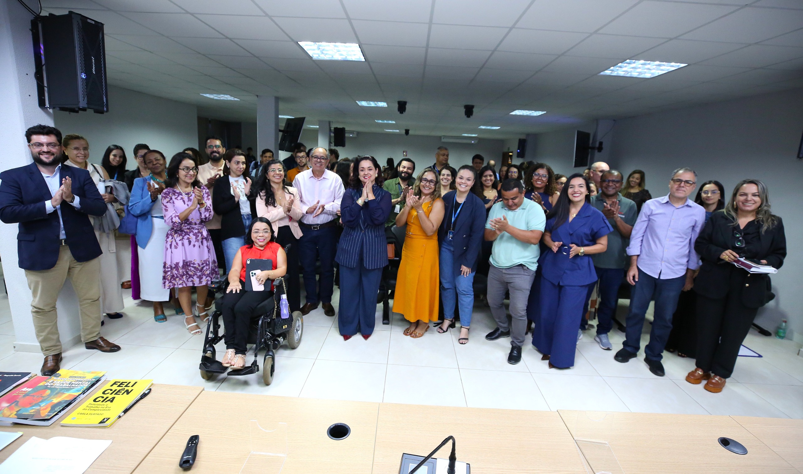 A imagem mostra um grupo de servidores(as), magistrados(as) e colaboradores(as), em pé e uma participante sentada em cadeira de rodas, posando para a foto,  durante atividade do curso Prevenção e Enfrentamento do Assédio Moral, Sexual e da Discriminação no Poder Judiciário.