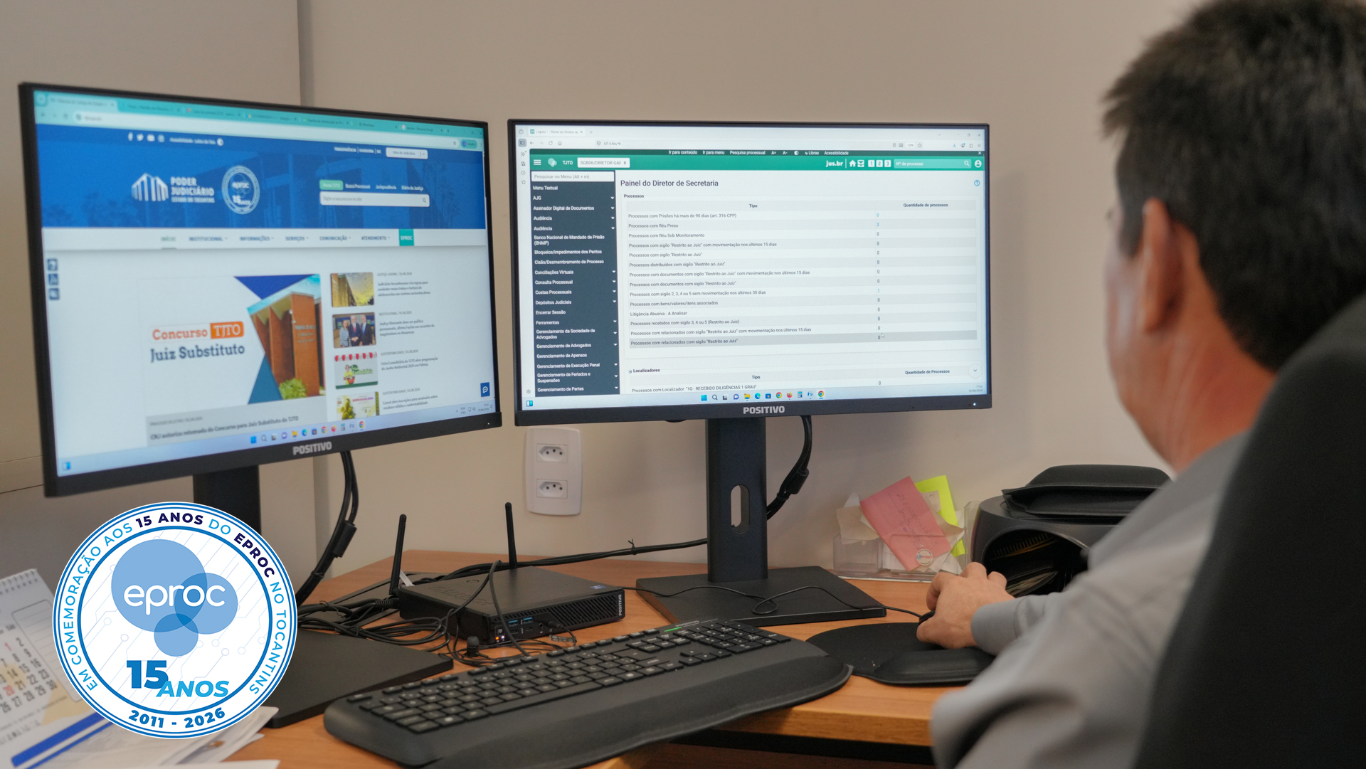 Servidor utiliza o sistema eproc em estação de trabalho equipada com dois monitores, acessando simultaneamente páginas do Portal do Poder Judiciário do Tocantins e do sistema processual eletrônico. A imagem integra as comemorações pelos 15 anos do eproc no TJTO.