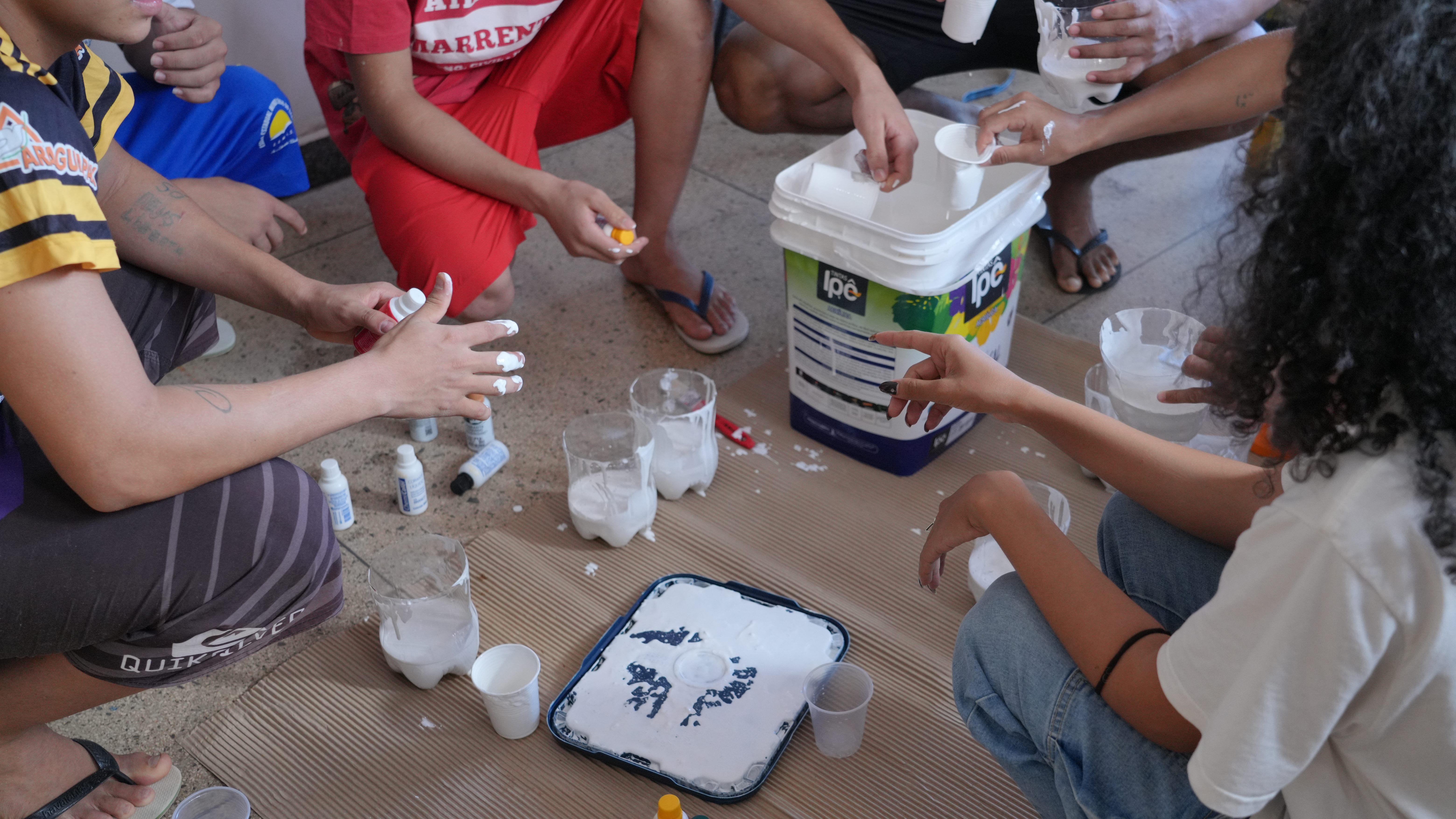 Adolescentes e estudantes da Universidade Federal do Tocantins preparam tintas e materiais utilizados na produção do mural artístico do projeto Caminhos Literários, desenvolvido no Case de Palmas.