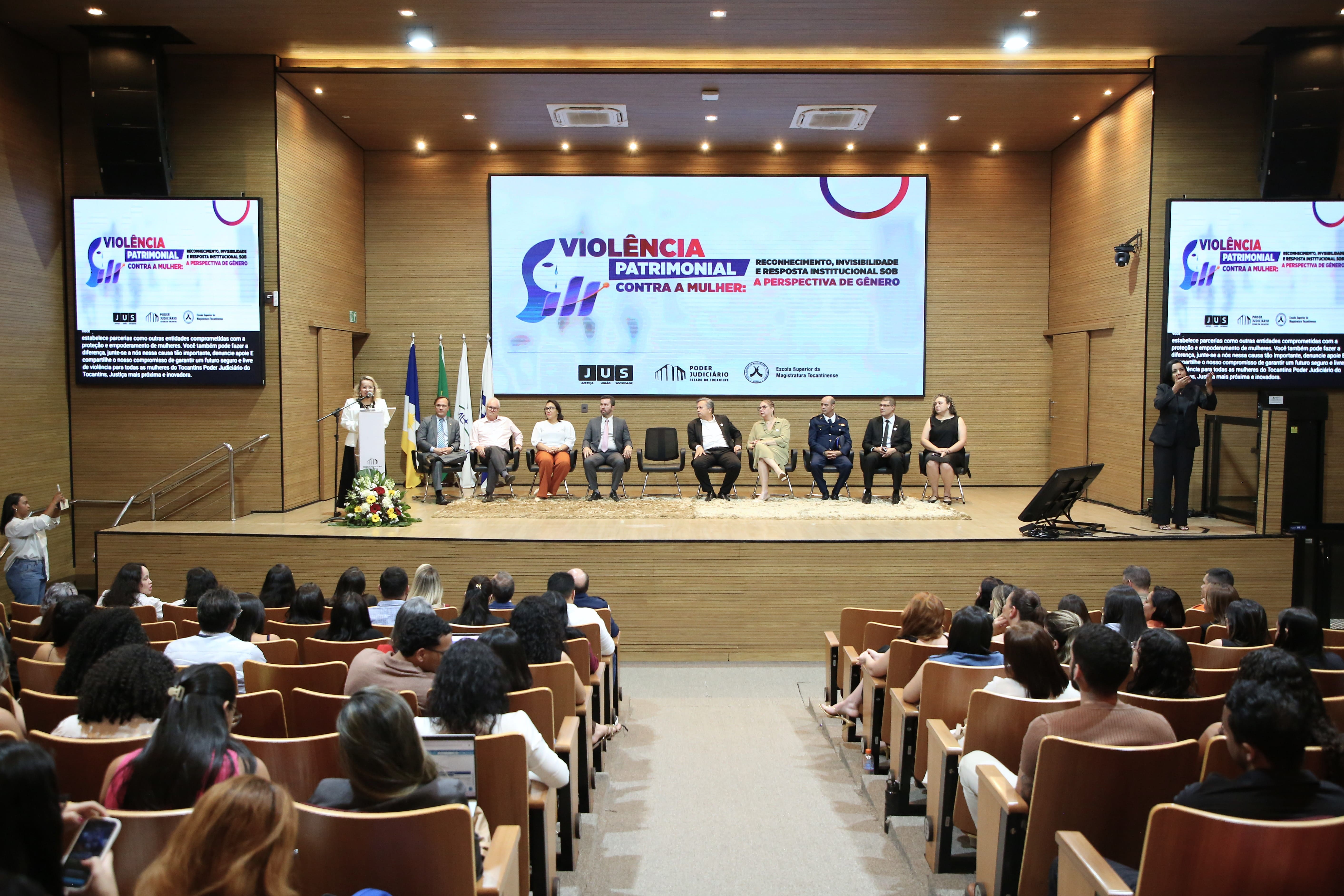 A imagem mostra o auditório do Tribunal de Justiça do Tocantins durante o evento “Violência Patrimonial Contra a Mulher”, reunindo autoridades, especialistas e o público para debater o tema sob a perspectiva de gênero.