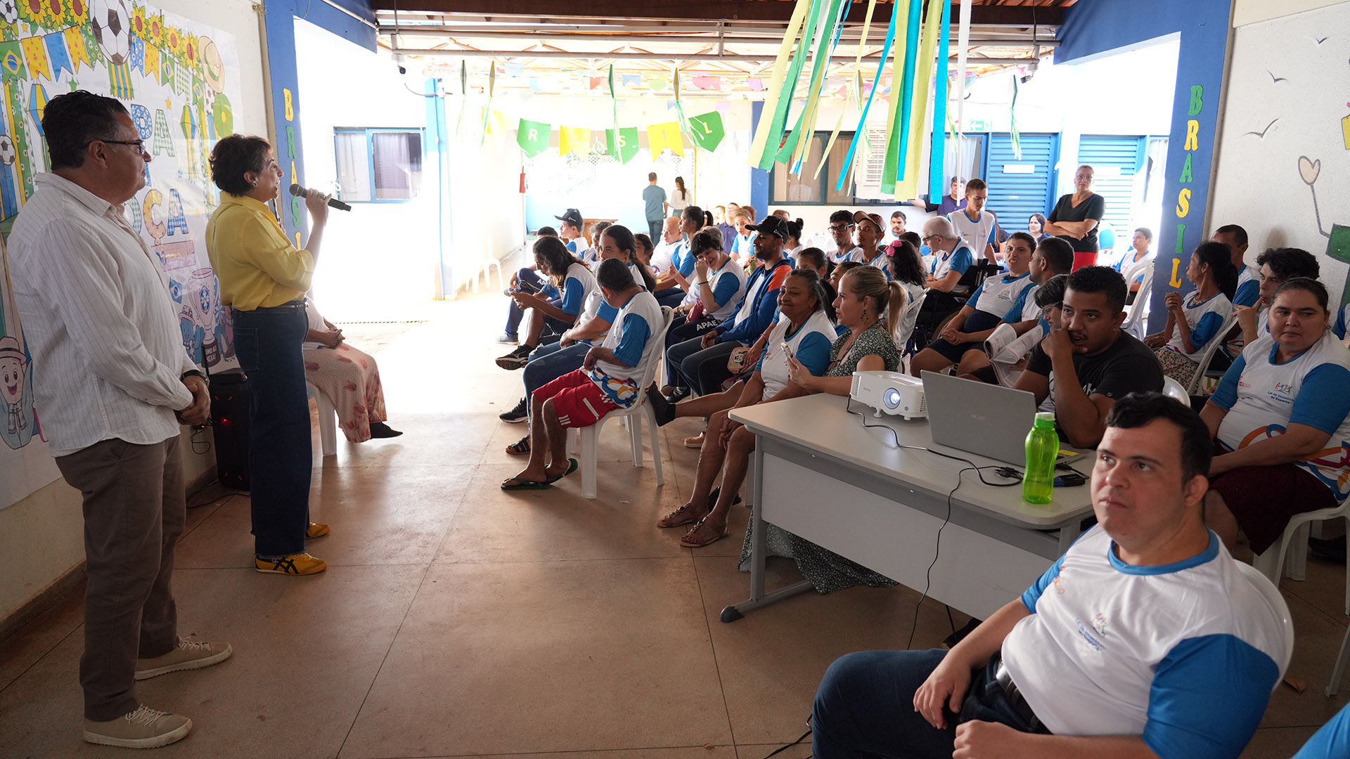 A presidente da Comissão Permanente de Acessibilidade e Inclusão (CPAI) do Tribunal de Justiça do Tocantins, desembargadora Angela Haonat, dirige-se aos estudantes, familiares, profissionais e colaboradores da Apae de Palmas durante a abertura do 1º Festival TEAtivo – Copa do Mundo. Ao lado de representantes da instituição, ela destaca a importância da inclusão, da acessibilidade e da aproximação entre o Poder Judiciário e a comunidade.
