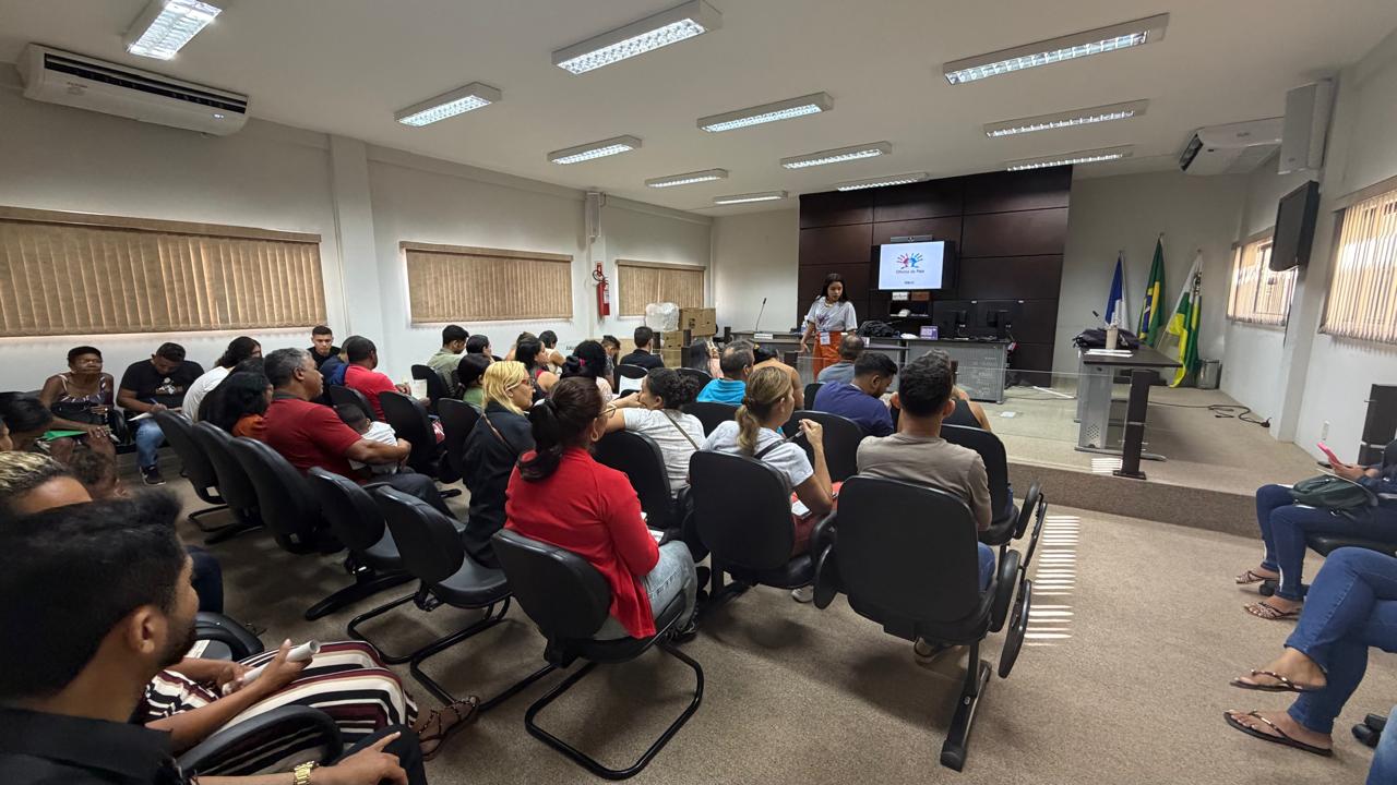 Foto mostra participantes sentados na sala do Juri de Itaguatins durante oficina para pais e filhos