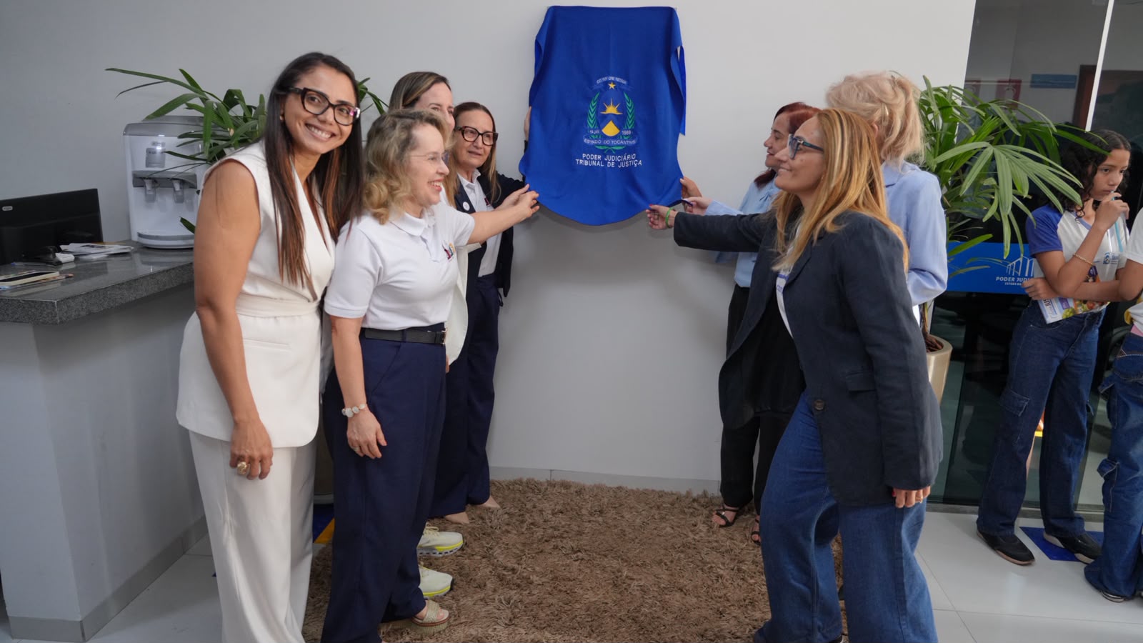 Pessoas em volta de uma placa coberta por pano durante descerramento da placa de inauguração do novo forum de itacaja