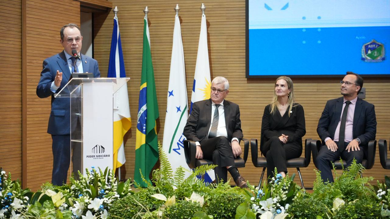 O diretor-geral da Escola Superior da Magistratura Tocantinense (Esmat), desembargador Marco Villas Boas, faz pronunciamento durante a abertura do IV Encontro Interinstitucional do eproc, no auditório do Tribunal de Justiça do Tocantins. Ao fundo, autoridades acompanham a cerimônia, realizada em celebração aos 15 anos de implantação do sistema eproc no Judiciário tocantinense.