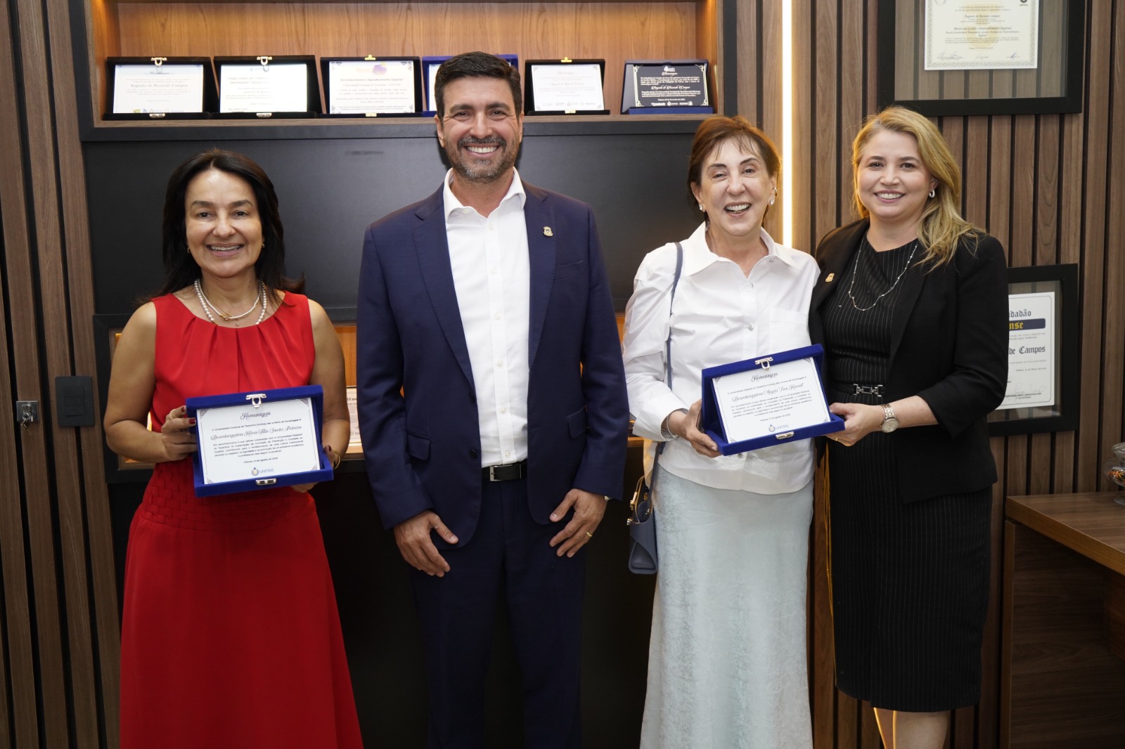 As desembargadoras Ângela Haonat e Hélvia Túlia recebem placas de homenagem do reitor da Unitins, Augusto Rezende, e da vice-reitora, Darlene Teixeira Castro, durante encontro no Gabinete da Reitoria.