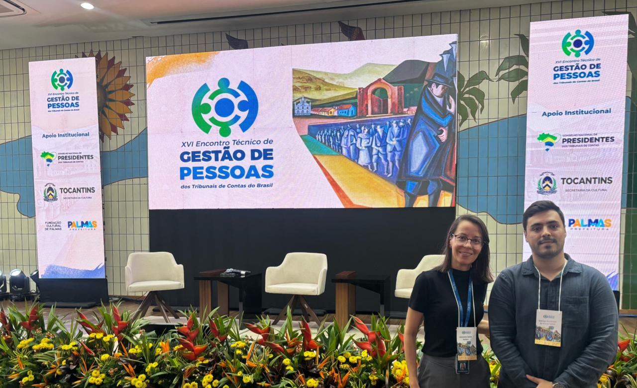 A imagem mostra Alessandra Santos Santana e Matheus Wanderlaan de Alencar Batista, servidores da Diretoria de Gestão de Pessoas do TJTO, de pé no palco do "XVI Encontro Técnico de Gestão de Pessoas".