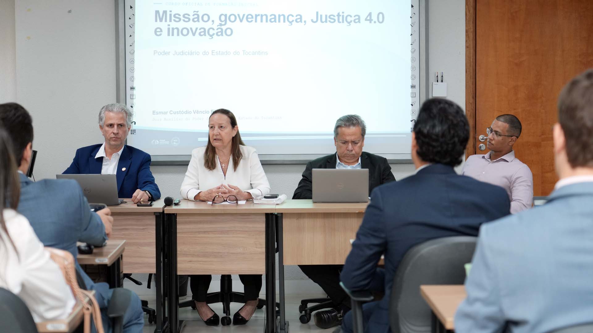A imagem mostra a presidente do TJTO, desembargadora Maysa Vendramini Rosal, e outras três autoridades sentadas, ministrando o curso durante a Formação Inicial de Magistrados e Magistradas do Tocantins. A aula aborda temas relacionados à segurança institucional e à inteligência estratégica no Poder Judiciário.