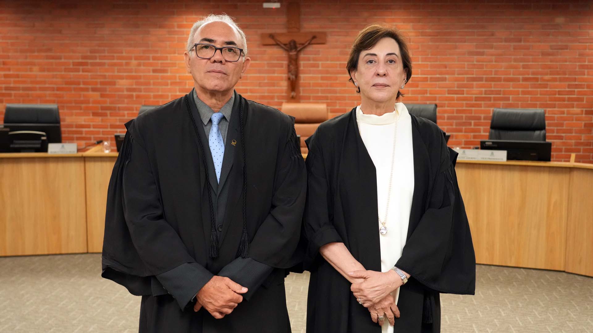 O desembargador Adolfo Amaro Mendes, eleito corregedor-geral da Justiça do Tocantins, e a desembargadora Ângela Issa Haonat, eleita vice-corregedora para o biênio 2027–2029, posam lado a lado no plenário do Tribunal de Justiça. Ambos trajam togas pretas da magistratura.