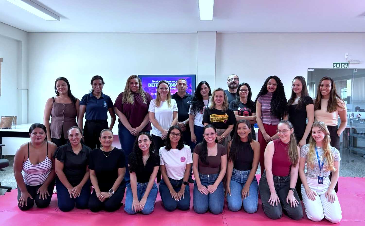 A imagem mostra um grupo de mulheres reunidas para a segunda turma do curso “Técnicas de Segurança e Defesa Pessoal para Mulheres”, no Fórum de Porto Nacional.