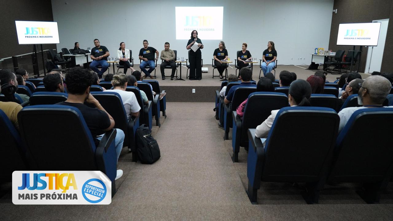 Grupo de pessoas sentadas em cadeiras azuis escutando atentamente a presidente do TJTO Etelvina que está posicionada no centro.